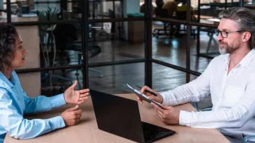 Dos personas tienen una reunión en una oficina moderna.