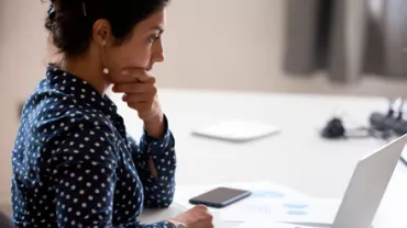 Mujer analizando ofertas frente a la computadora